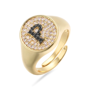 Detalle macro del anillo de sello dorado con pavé de circonitas y la letra P