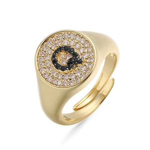 Vista macro del anillo de sello dorado con circonitas blancas y detalle de la letra Q negra