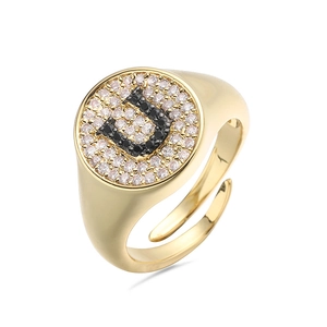 Vista macro detallada del anillo letra U dorado con pavé de circonitas blancas y negras