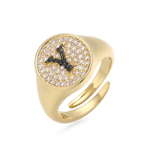 Detalle del anillo letra Y con circonitas blancas y cristales negros en acabado dorado