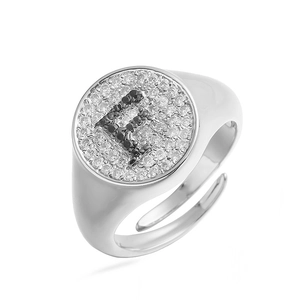 Detalle de anillo plateado con letra F en pavé de circonitas cúbicas blancas y negras