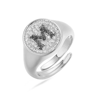 Vista macro detallada de un anillo de sello ajustable con letra M y circonitas brillantes