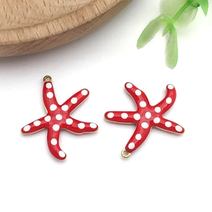 Detail of red enamel starfish pendants with white polka dots for DIY jewelry making