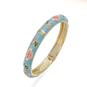 Detailed macro view of vintage light blue enamel hinge bracelet with floral patterns