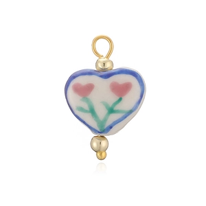 Détail du pendentif en céramique en forme de cœur avec motifs floraux peints et boucles d'or