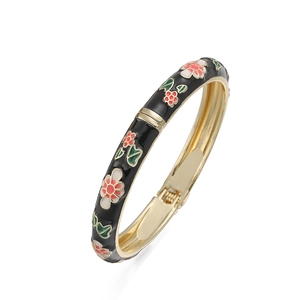 Close-up of vintage floral enamel bracelet with gold frame and hinge clasp detail