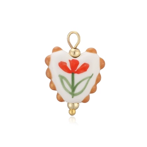 Détail d'un pendentif en céramique en forme de cœur avec motif tulipe et bordure dorée