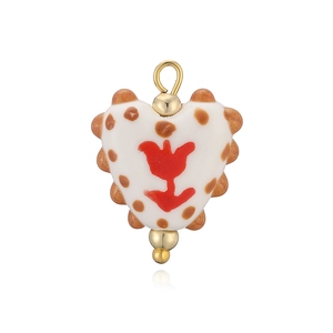Détail d'un pendentif cœur en céramique avec tulipe rouge et points marrons