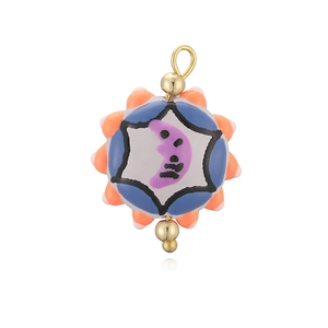 Détail macro d'un pendentif lune en émail coloré avec perles dorées et finition polie