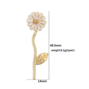 Daisy pendant earrings with white enamel petals and golden stem details on white background