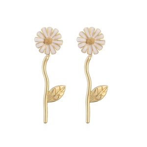 Macro detail of long daisy drop earrings with white petals and golden stems