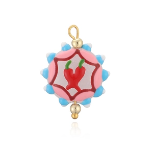 Vue détaillée du pendentif émaillé avec motif de piment rouge et perles dorées