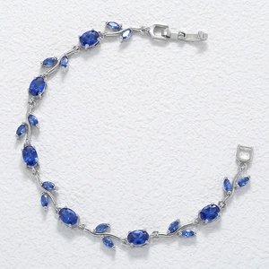 Macro detail of silver vine bracelet with deep blue marquise gemstones and fold-over clasp