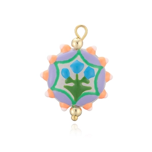 Détail d'un pendentif en céramique lavande fait main avec motifs floraux et perles dorées