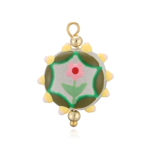 Détail macro du pendentif rond en céramique avec motif floral rose peint à la main