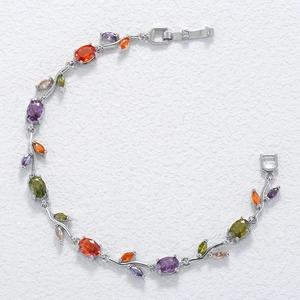 Detailed macro view of vine-shaped silver bracelet with colorful inlaid gemstones