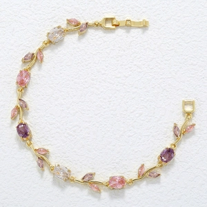 Detail shot of golden vine bracelet with multi-colored crystals and floral leaf design