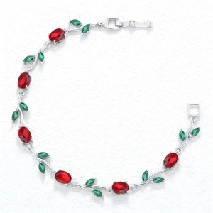 Macro shot of silver vine bracelet with red oval gems and green marquise stones