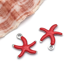 Gros plan de breloques étoile de mer en émail rouge et doré pour bijoux DIY