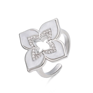 Detalle de anillo ajustable de trébol plateado con nácar blanco y cristales pavé finos