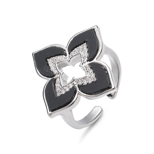 Primer plano de anillo trébol plateado con esmalte negro y microcircones blancos pavé