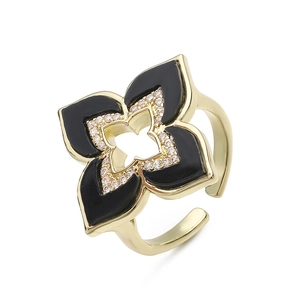 Detalle de un anillo trébol dorado con pétalos de esmalte negro y circonitas brillantes