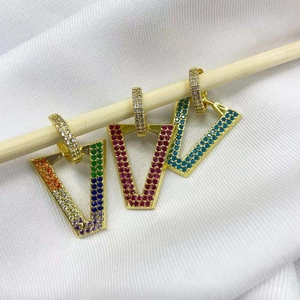 Detail of micro-paved V-shape earrings with colorful cubic zirconia and gold plating