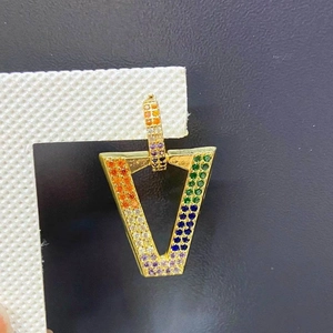 Macro shot of V-shaped gold earrings with colorful gradient pavé rainbow zircons