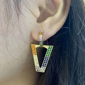 Macro view of geometric gold triangle earrings with vibrant rainbow micro-pave crystals