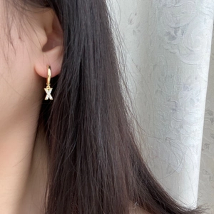 Gold plated hoop earring with micro-pave zircon letter X pendant worn on female ear