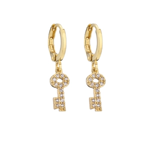 Macro view of gold key pendant earrings featuring micro-pave cubic zirconia crystals