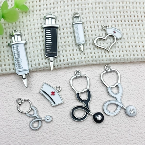Detailed view of medical charms showing syringe and nurse hat with sparkling rhinestones