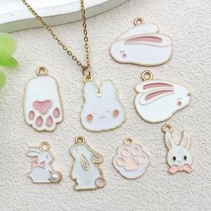 Macro detail of assorted enamel rabbit charms and pink cat paw pendants for DIY jewelry