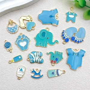 Detalle de dijes esmaltados en azul con temática de bebé y elefantes para joyería DIY