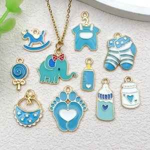 Detalle de dijes de esmalte azul con elefante, biberón y calcetines para joyas de bricolaje