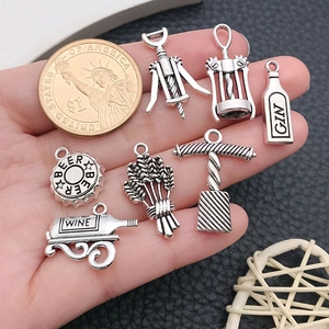 Detailed antique silver wine themed charms set with a dollar coin for scale reference