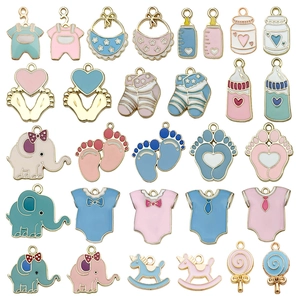 Detalle de dijes de bebé en esmalte rosa y azul con biberones para joyería de bricolaje