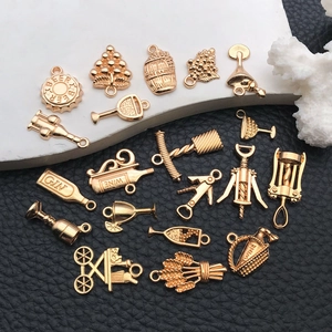 Detailed view of gold alloy wine charms including wine bottles, barrels and grapes
