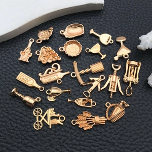 Macro view of gold vintage wine themed charms including bottles and grape cluster