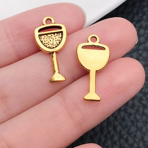 Close-up of golden antique wine glass pendants with metallic texture and ring bail