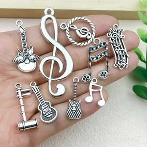 Antiek zilveren muzieknoot en gitaar bedeltjes voor DIY sieraden maken in de hand