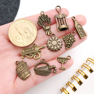 Detailed antique bronze wine pendants shown with a coin for size reference