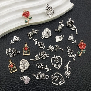 Detailed macro view of assorted rose flower alloy pendants and DIY jewelry charms on leather