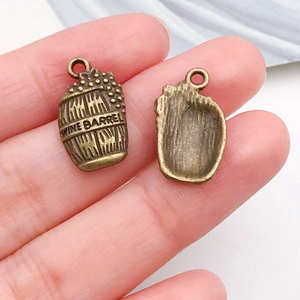 Detailed close-up of antique bronze wine barrel charms featuring wine barrel engraving