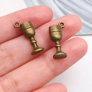 Detail view of retro bronze wine glass pendant charm held in hand for DIY jewelry