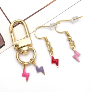 Detail of lightning bolt charms on a gold keychain and matching hook earrings