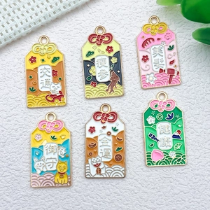Close-up of six Japanese omamori enamel charms with gold finish and vibrant colors