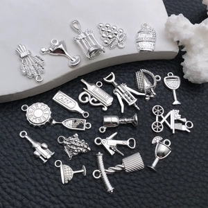 Macro detail of silver alloy wine charms including wine bottles, glasses and grape pendants