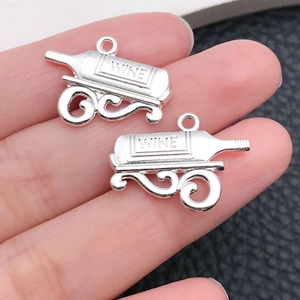 Close-up of vintage silver alloy wine bottle pendant with wine engraving and metal rack