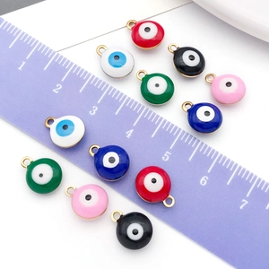 Macro shot of colorful round Evil Eye charms in multiple colors with ruler for size scale